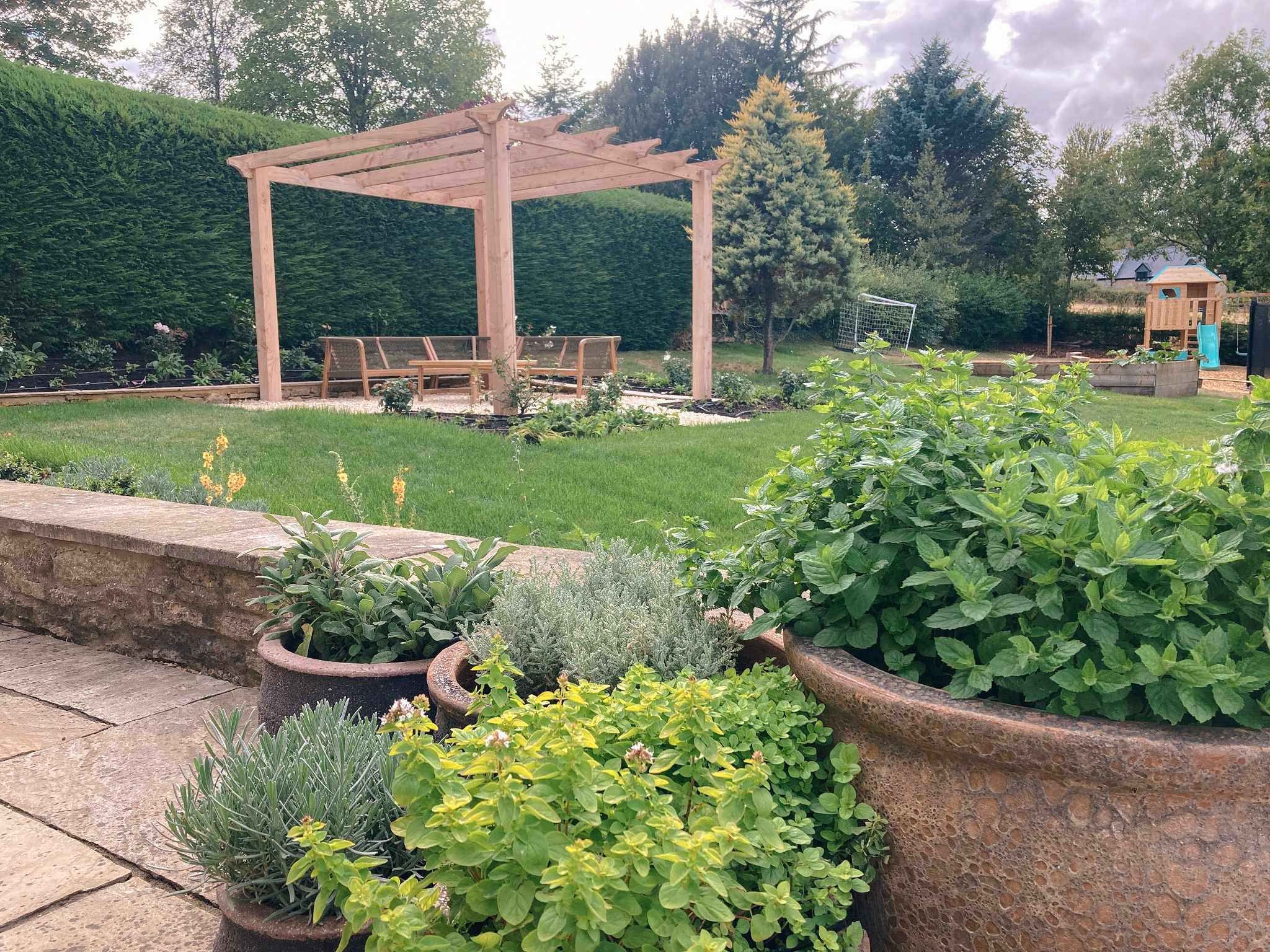 Country garden border planting overlooking a large lawn in Chipping Norton